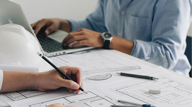 Engineer constuction and interior team dissussing in the office. and angineer working drawing on blueprint meeting for project working with a partner on model building plans at table in a modern office.construction concept.  