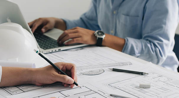 Engineer constuction and interior team dissussing in the office. and angineer working drawing on blueprint meeting for project working with a partner on model building plans at table in a modern office.construction concept.  